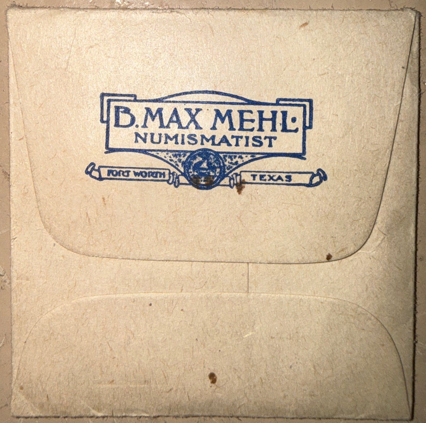 Envelope with 'B. Max Mehl Numismatist' branding on a textured beige background